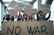 © CarlosBarquero - Multitude of different people silently protesting against war and violence in world with serious gesture. Group of various activists with anti-war banners at demonstration for peace and human rights