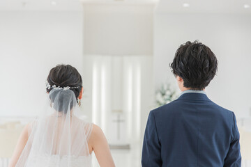 Wall Mural - 結婚式場・チャペル・教会を歩く新郎新婦の後ろ姿（入場・結婚式・アジア人）
