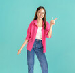 © sitthiphong - Portrait of confident Asian business woman casual pink shirt hands point to the side isolated on blue background.