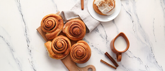 Wall Mural - Wooden board and plate with sweet cinnamon rolls on white background