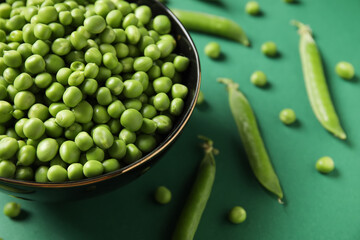 Wall Mural - Bowl with fresh green peas on color background