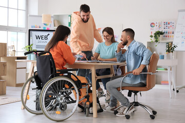 Wall Mural - Team of designers working with colleague in wheelchair at office