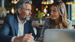 © Raja - two business people working together on laptop