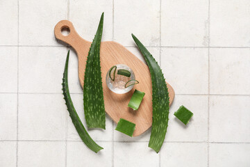 Sticker - Wooden cutting board with fresh aloe vera leaves on beige tile background