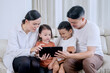 © Creativa Images - Happy Family Laughing Together While Using a Tablet at Home