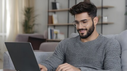 Aufkleber - Young Middle Eastern Man Focused on Studying with Laptop and Textbook at Home for His Online Educational Course