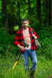 © Volodymyr - Lumberjack cutting the tree by the axe. Handsome man with an ax in the forest. Handsome man or lumberjack, bearded hipster in checkered shirt with axe. A bearded lumberjack with a large ax.