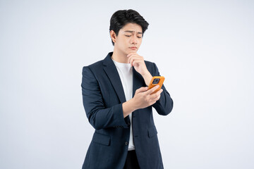 Wall Mural - Portrait of young Asian business man using phone and posing on white background