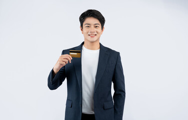 Wall Mural - Portrait of young Asian business man holding bank card and posing on white background