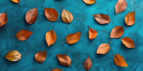 Wall Mural - Autumn leaves in warm orange hues scattered on a textured blue background viewed from above create a vibrant seasonal aesthetic.