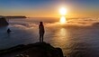 © Photo by mQ - A silhouette of a person standing on the edge of a cliff, gazing at a golden sunrise over the vast ocean, capturing a moment of awe and tranquility.