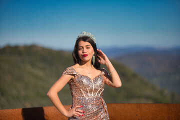 Latin brunette woman, young and beautiful is dressed in golden sequined dress and a crown of rhinestones has won a beauty contest. Beauty and fashion concept.