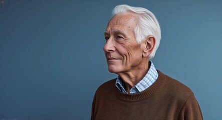 Canvas Print - Elderly Caucasian man in plain blue background brown sweater side view portrait