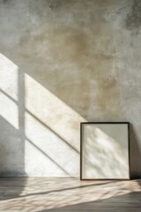 Poster - Minimalist picture frame resting against textured wall with natural light streaming through window