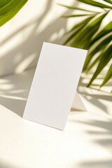 Poster - Mockup of a blank business card on a smooth surface with complementary greenery in bright natural light