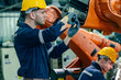 © Hip.hub - Skilled workers maintain robotic equipment in a manufacturing facility during daytime