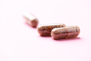 Wall Mural - Siberian ginseng (Eleutherococcus senticosus) capsules on bright background. Soft focus. Close up. Copy space.	