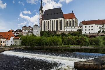 Wall Mural - View of Cesky Krumlov with historic buildings and a river under a blue sky.