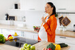 © Home-stock - Pregnant woman happily tasting fresh salad in kitchen, showing healthy lifestyle during pregnancy, copy space