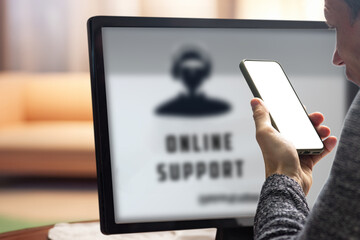 Poster - Young man needing online help with setting up device talking with tech support. Man interacting with online support through a computer, showcasing seamless communication, from behind the monitor