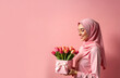 © Elena Verba - Portrait of a smiling Muslim woman with a bouquet of flowers in her hands. Banner, postcard template for March 8, World Women's Day, Mother's Day, equality. Selective focus, a place for the text.