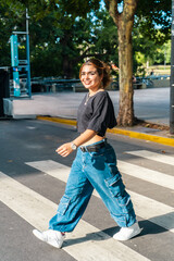 Wall Mural - Young woman confidently walking on crosswalk