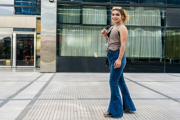 Wall Mural - Young woman walking confidently in urban setting