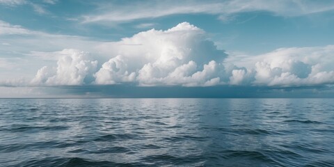 Wall Mural - Ocean view with calm water and dramatic clouds under a clear blue sky during daytime. Natural landscape and seascape photography.