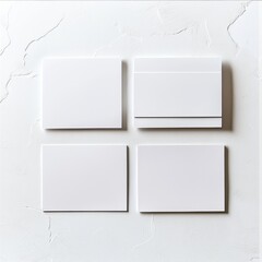 Poster - A clean, minimalist mockup featuring four square white canvases or frames against a textured white wall, providing space for art or graphic designs, ready for display.