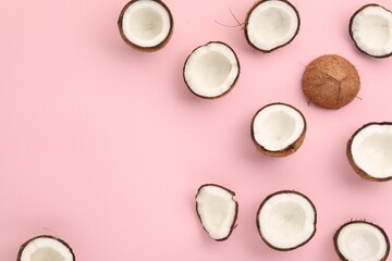 Wall Mural - Pieces of cracked coconuts on pink background, flat lay. Space for text