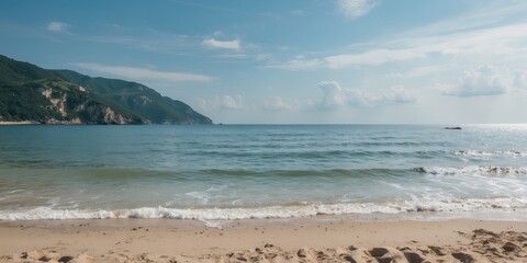 Canvas Print - Scenic beach view with gentle waves and distant mountains under a clear sky in a tranquil coastal landscape.