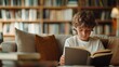 © Nattapol - Boy reading a book in a cozy library setting.