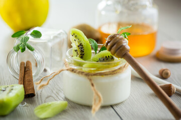 Poster - Homemade yogurt in a glass jar with honey, kiwi, nuts.