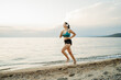 © Dusan - Young woman running or jogging on the beach at sunset