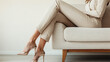 © Alina Tymofieieva - Elegant woman in gold heels seated in a modern living room showcasing contemporary fashion and design elements