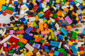 Wall Mural - Background, texture, close-up photograph of a top view of multi-colored parts of a plastic children's construction set.