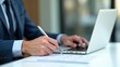 © Ada - Business man sending and receiving email on white table. Using laptop for writing mail