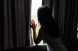 © Pattarisara - Teenager girl with sadness and depression looking out the window while sitting alone on sofa at home. Sad, unhappy, disappointed concept. Close up