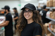 © Mselected - Smiling employee in a busy food service environment wearing a black cap and glasses