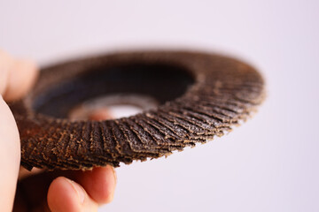 Poster - A person holds a small metal piece in their hand, possibly for inspection or use.