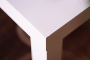 Poster - A close-up of a simple white table with a single flower sitting on it, great for use in home decor or wedding inspiration.