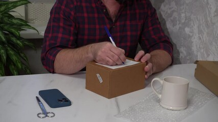 Wall Mural - the male person returns the damaged mug, making an inscription on the box at home in the kitchen