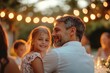© Marica - Joyful Multi-Generation Family Garden Party Celebration with String Lights and Lanterns Creating Magical Evening Atmosphere