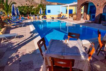 Luxury pool with scenic Santorini homes overlooking the Aegean Sea at sunset