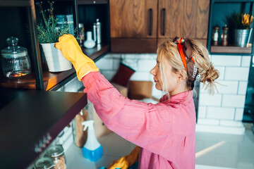 Woman organizing kitchen with potted plants