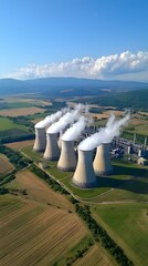 Poster - Aerial drone shot of a large nuclear power plant with multiple cooling towers releasing steam set against a rural countryside landscape with agricultural fields under a clear blue sky