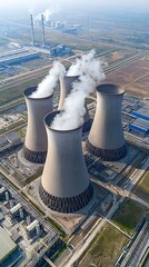 Poster - Aerial drone shot of a large nuclear power plant with multiple towering cooling towers emitting steam surrounded by an industrial landscape
