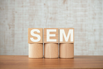 Poster - There is wood cube with the word SEM. It is an abbreviation for Search Engine Marketing as eye-catching image.