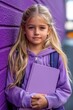 © Tatiana - Young girl with long hair poses against purple wall, holding a notebook, ready for school on a bright day