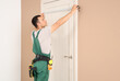 © Pixel-Shot - Male worker measuring door at home